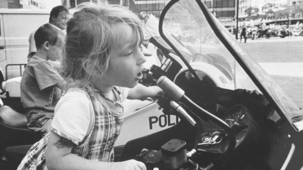 Schwarz-Weiß-Foto von Mädchen auf ausgestellten BMW Polizei Motorrad mit peiker Mikrofon