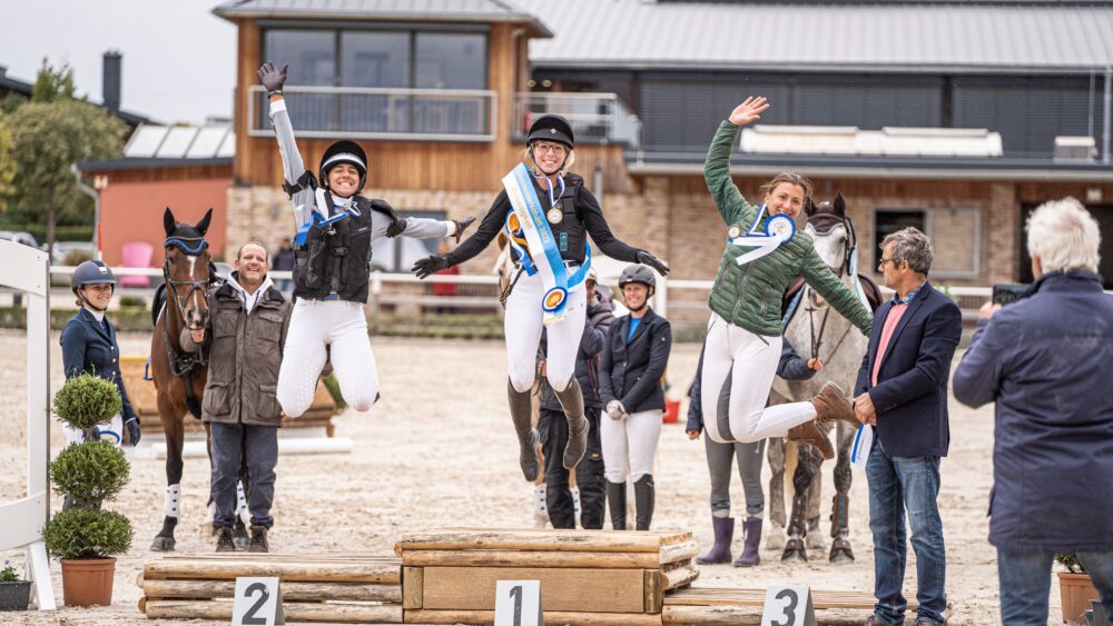 Sieger springen auf dem Siegertreppchen in die Luft