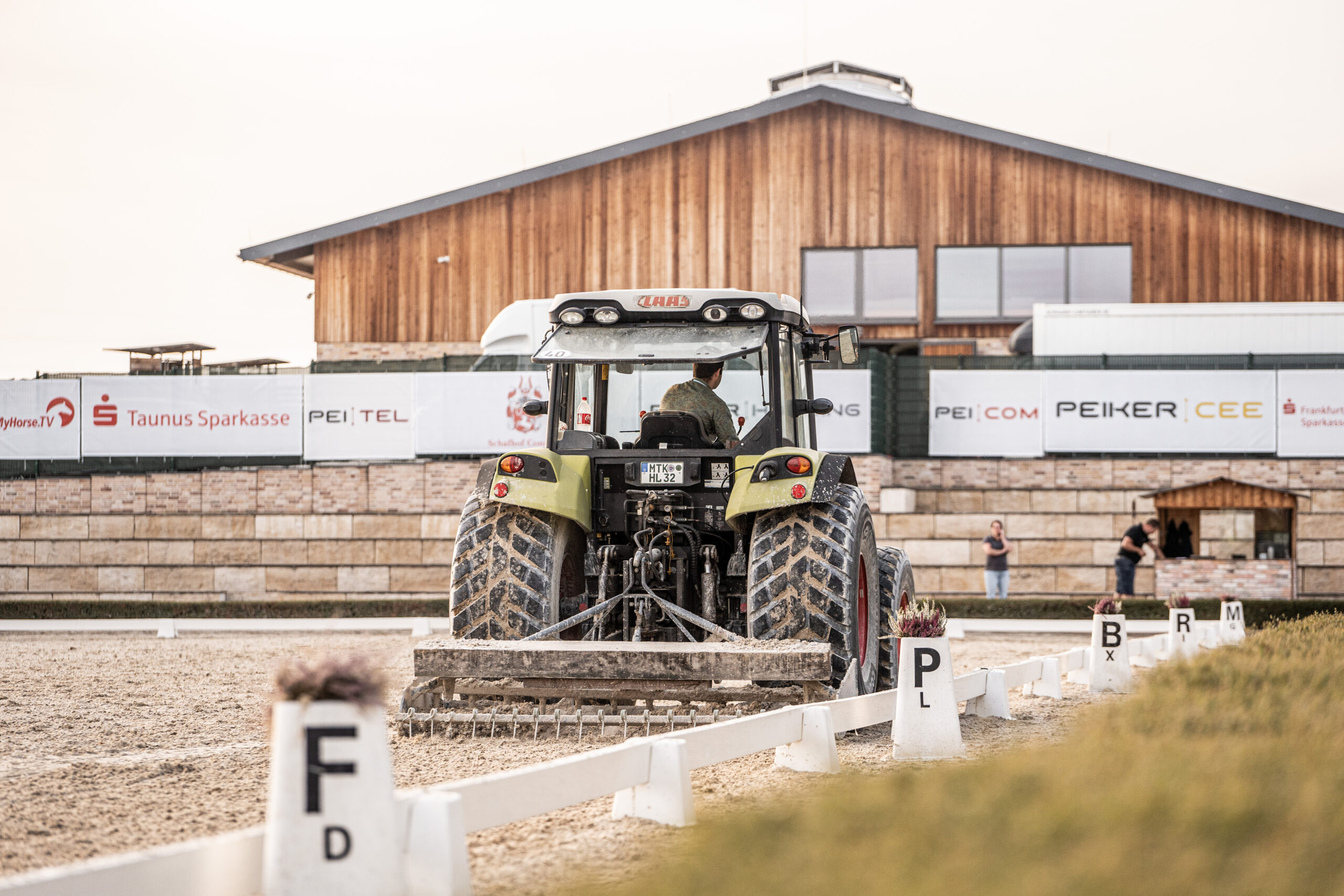 Skyline Cup Dressurviereck Traktor zieht den Platz ab